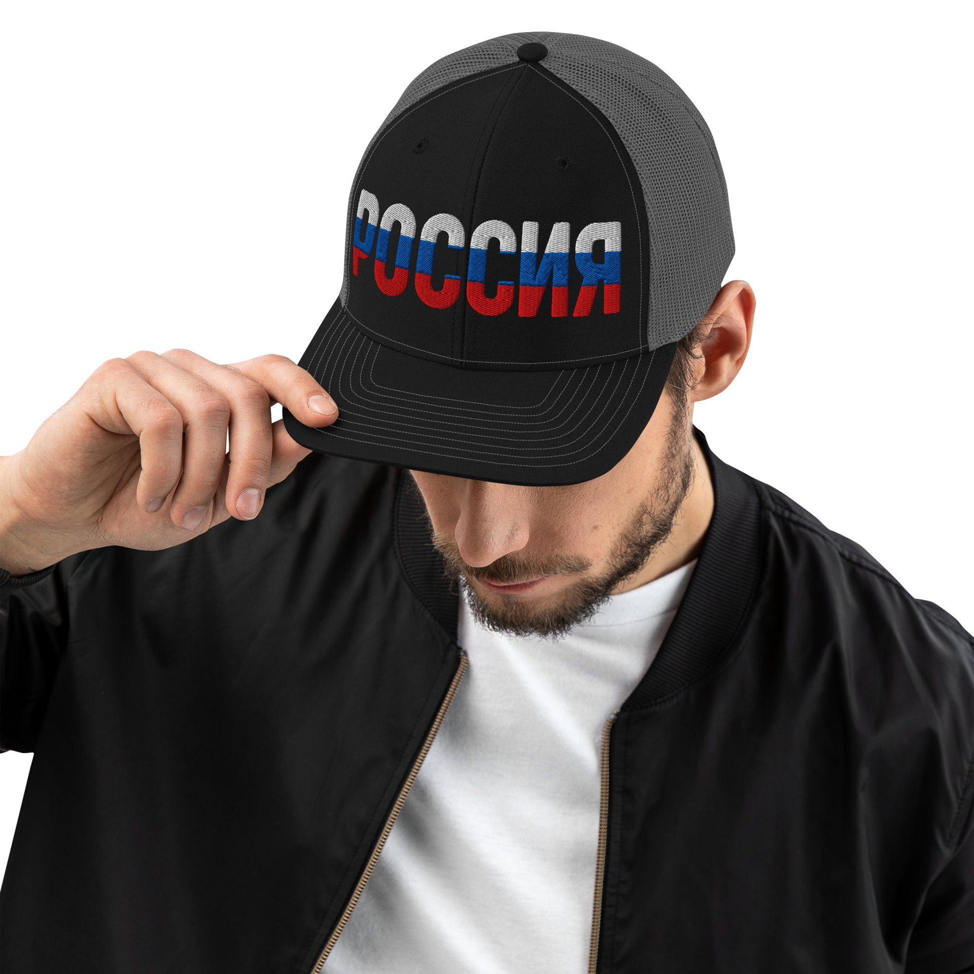 Man wearing a black and grey trucker hat with “ROSSIA” embroidered in Russian flag colors (white, blue, and red).