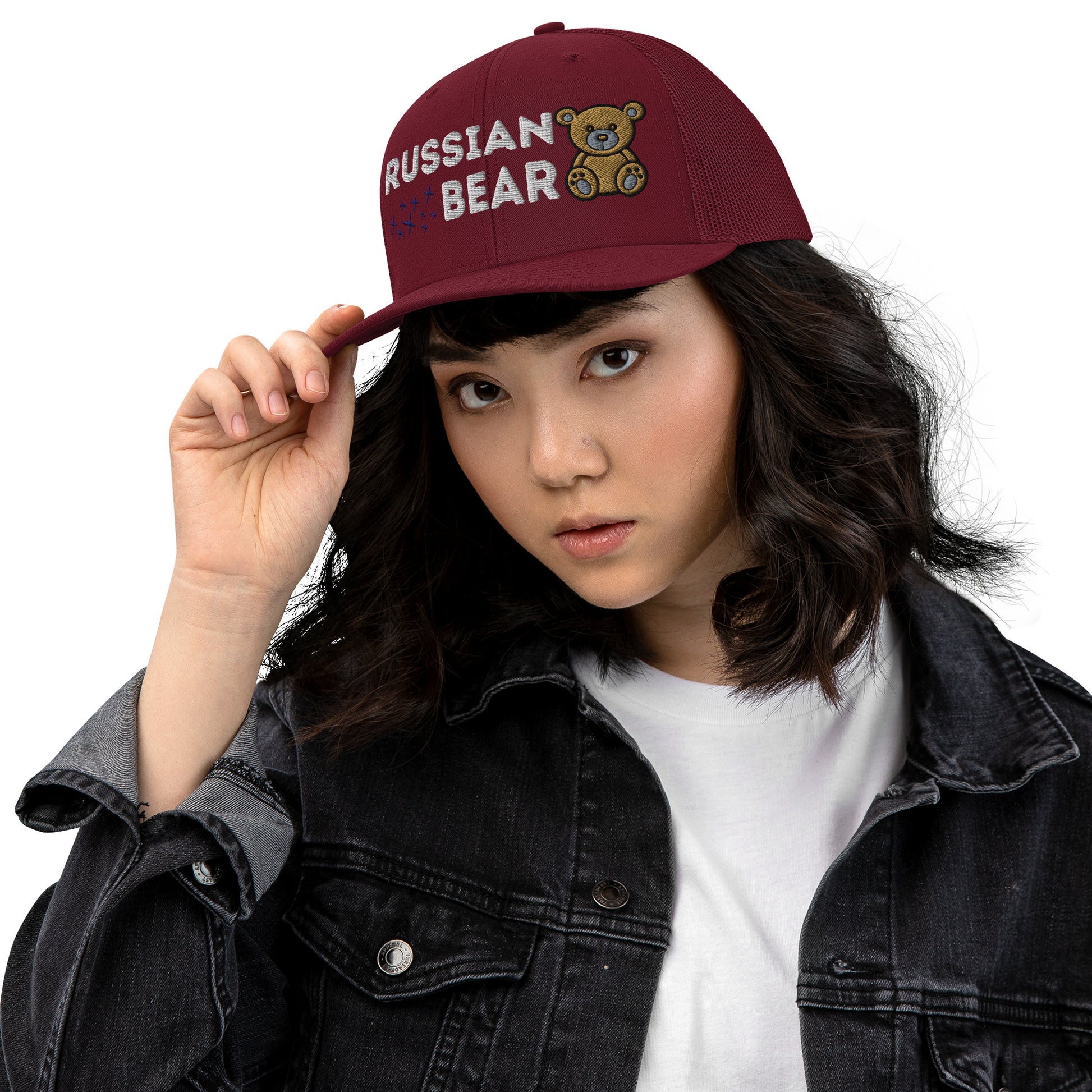 Woman wearing an embroidered trucker hat with 'RUSSIAN BEAR' text and cute bear design, featuring a structured front, red cardinal mesh back, and adjustable snapback closure.