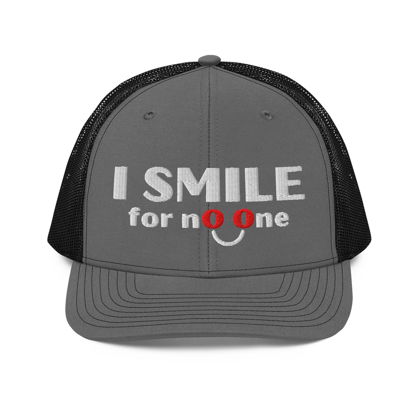 Grey and black trucker hat with embroidered text 'I Smile for No One' in bold white lettering. Structured cap with black mesh back and adjustable snapback.