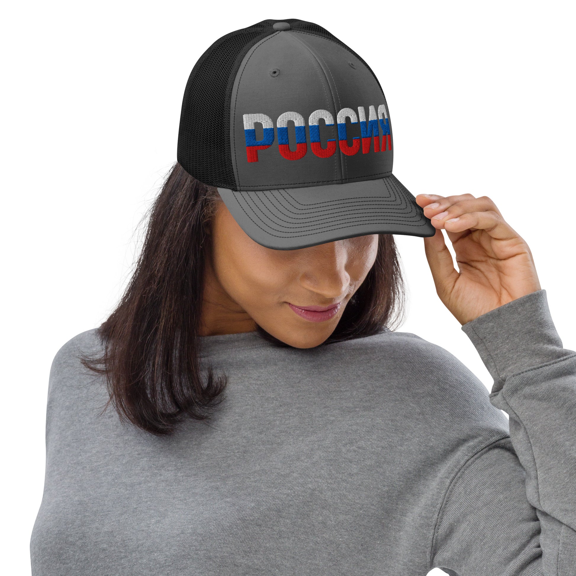 Woman wearing a grey and black trucker hat with “ROSSIA” embroidered in Russian flag colors (white, blue, and red).