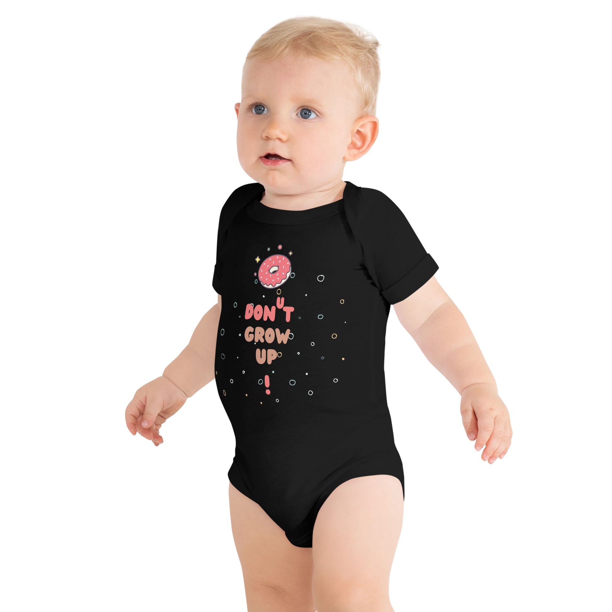 Baby in a black onesie with "Don't Grow Up!" with donut caption.