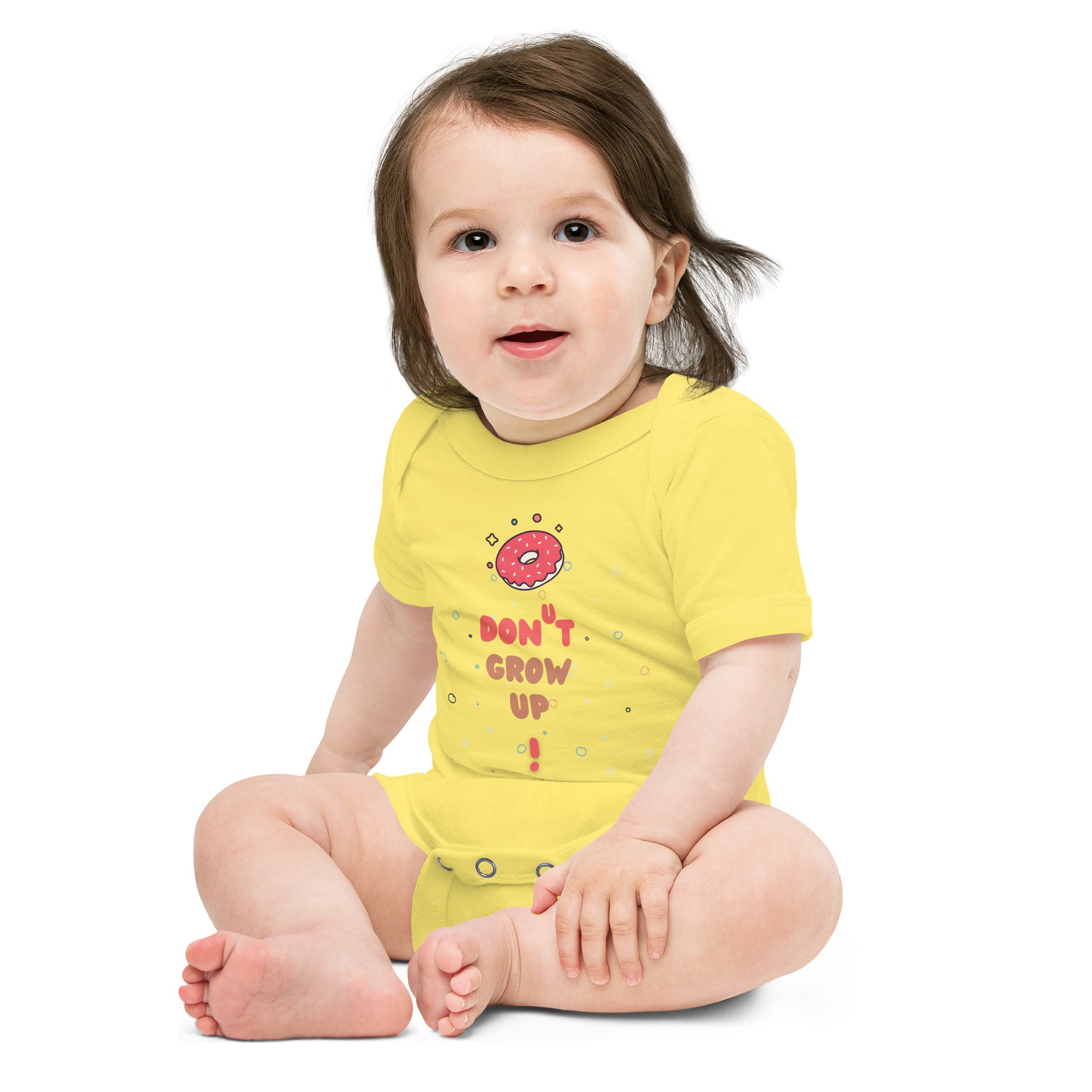 Baby in a yellow onesie with "Don't Grow Up!" with donut caption.