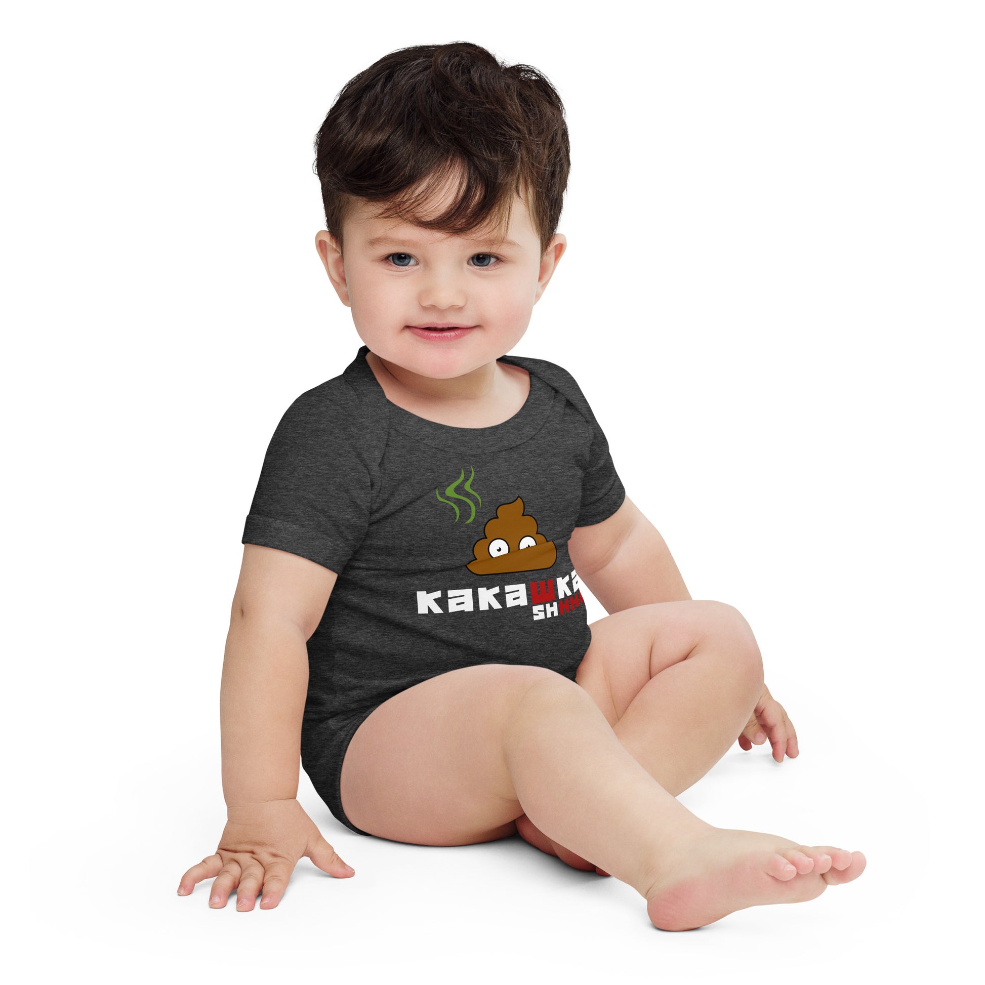 baby in dark grey one piece onesie with picture of poop and kakashka written on it