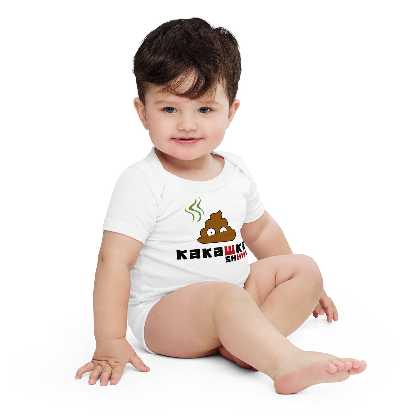 baby in white one piece onesie with picture of poop and kakashka written on it