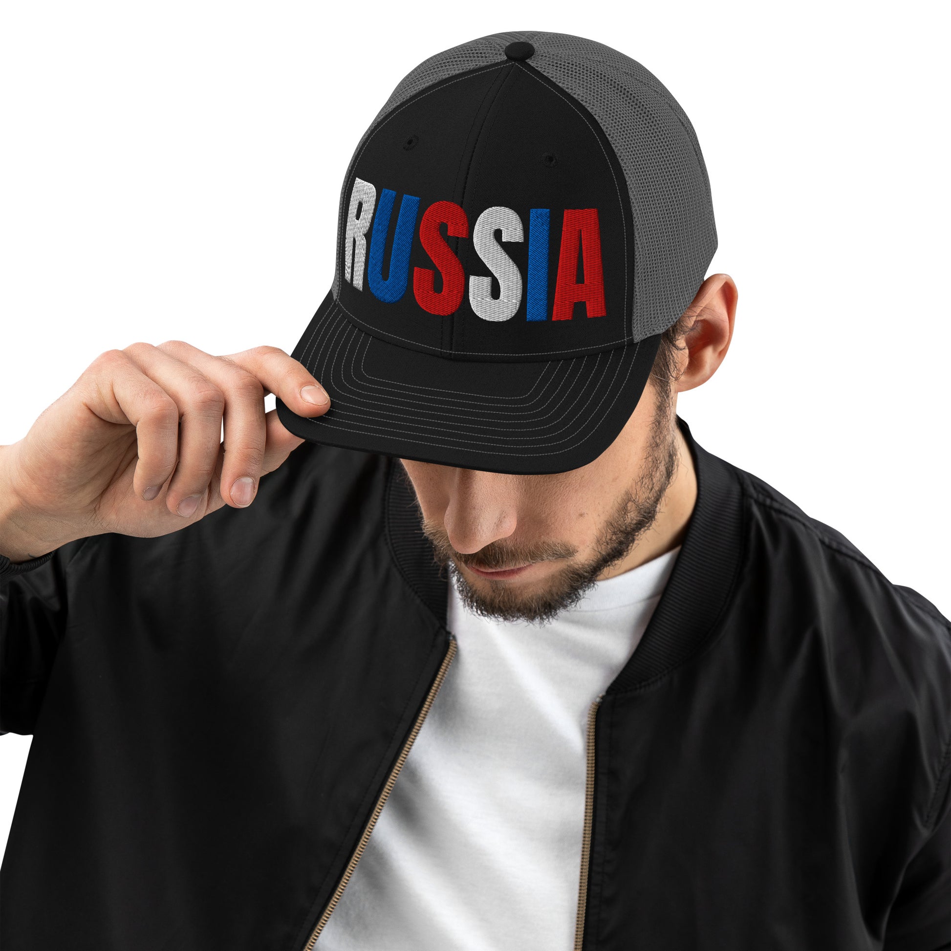 Man wearing an embroidered 'RUSSIA' trucker hat with Russian flag colors. Classic design featuring a cotton blend front, mesh back, and adjustable snapback for a comfortable, stylish fit.