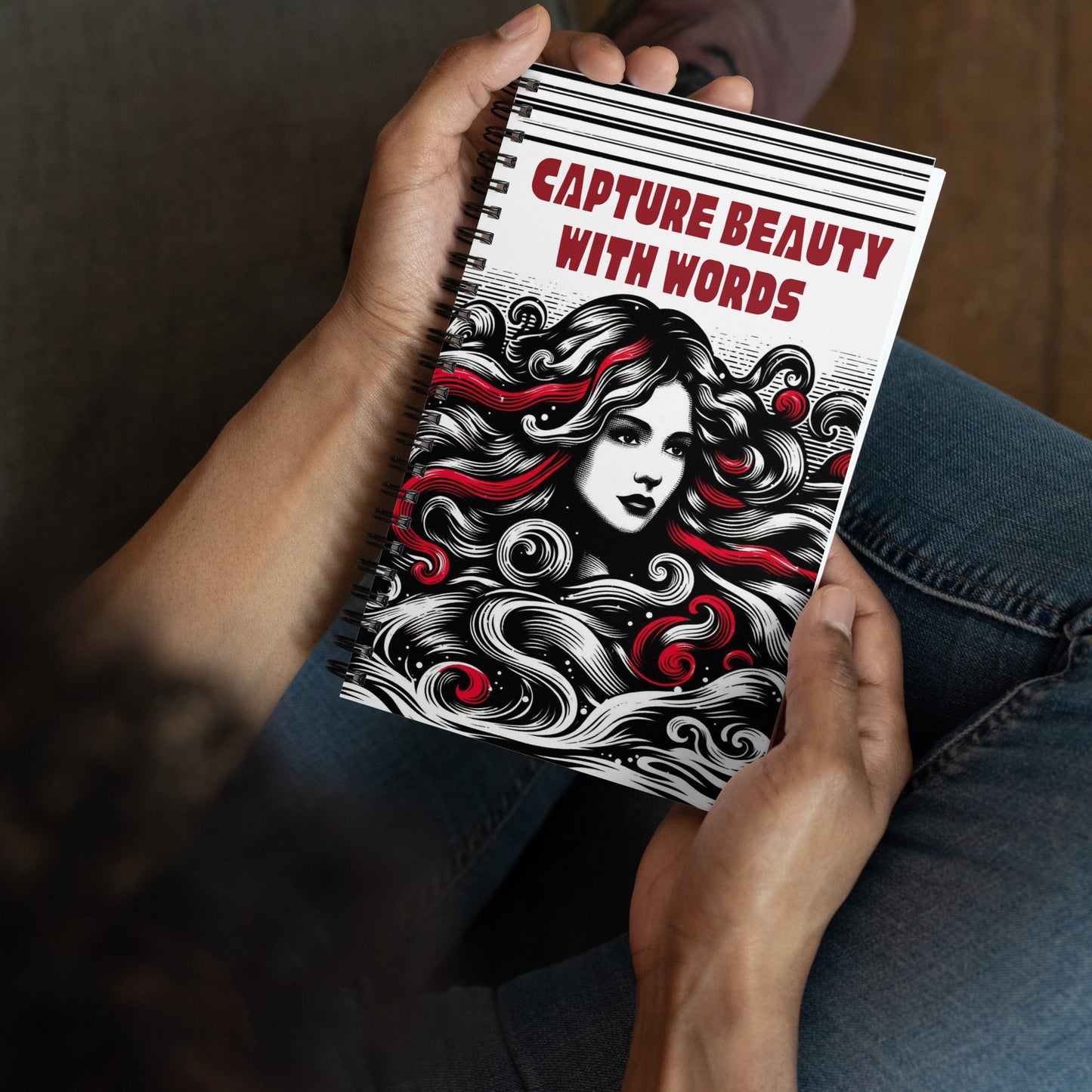 Spiral notepad with caption "Capture Beauty With Words" and a sketch of a beautiful woman in black, white, and red colors.