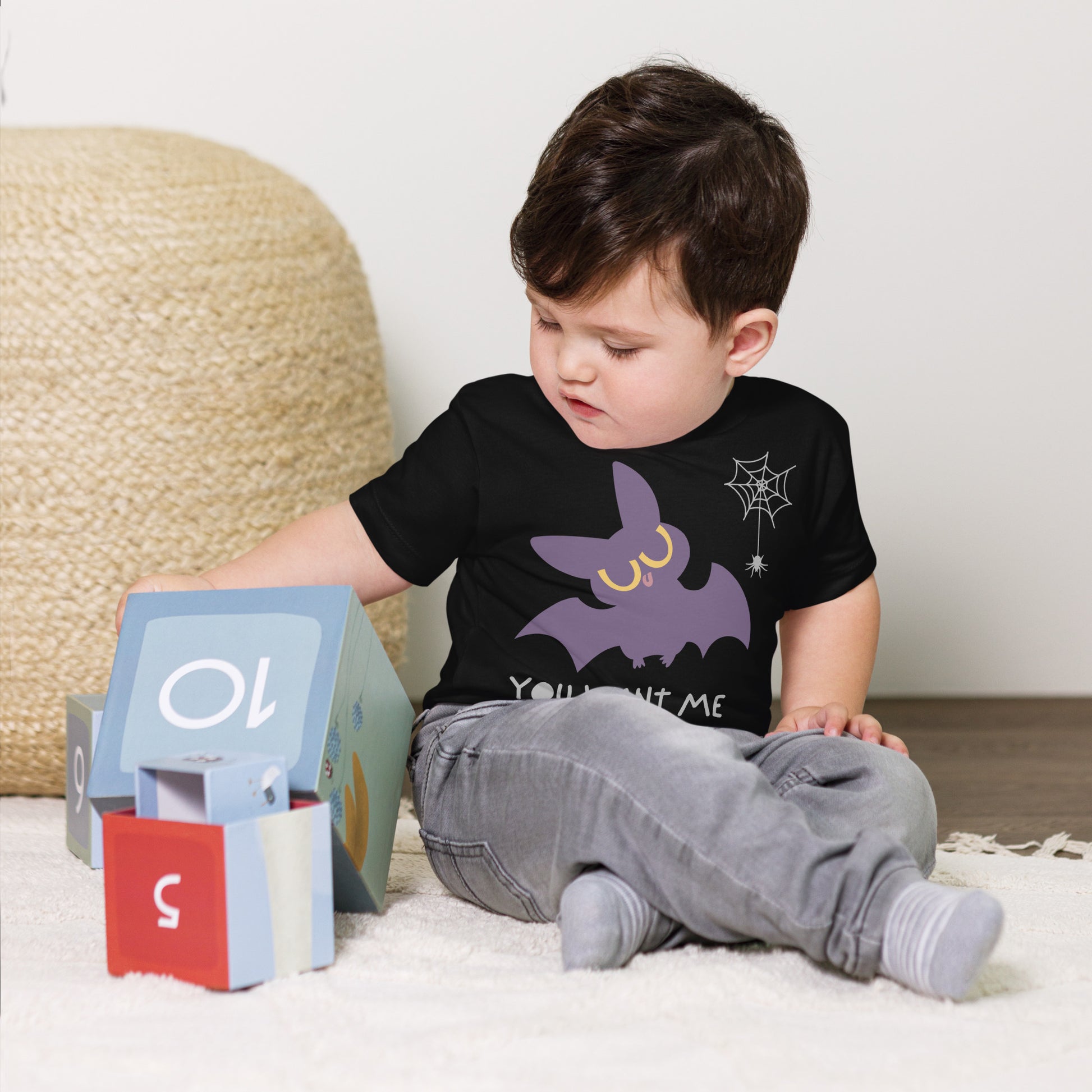 Toddler in a black cotton t-shirt with a cute bat next to a spider hanging off a spiderweb and caption "You Want Me To Eat THAT?!"