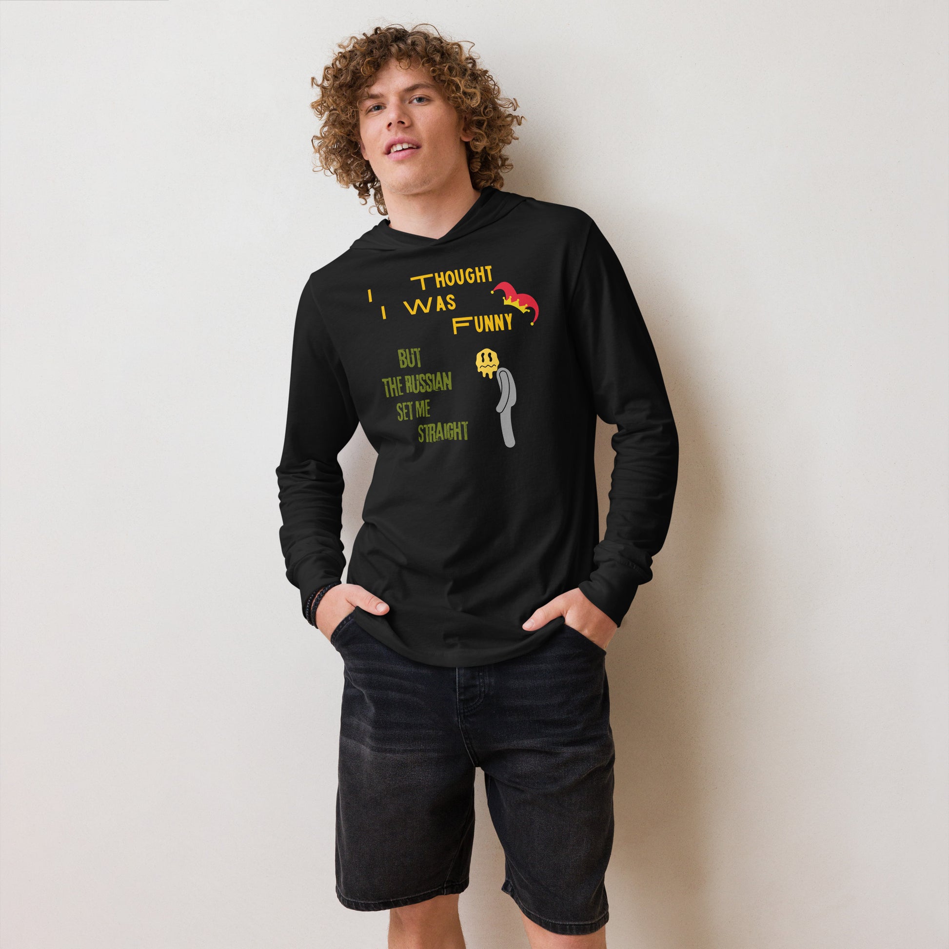 man in black unisex hoodie with i thought i was funny written in yellow and but the russian set me straight written in green a jasper hat is on funny and a sad man is next to green text