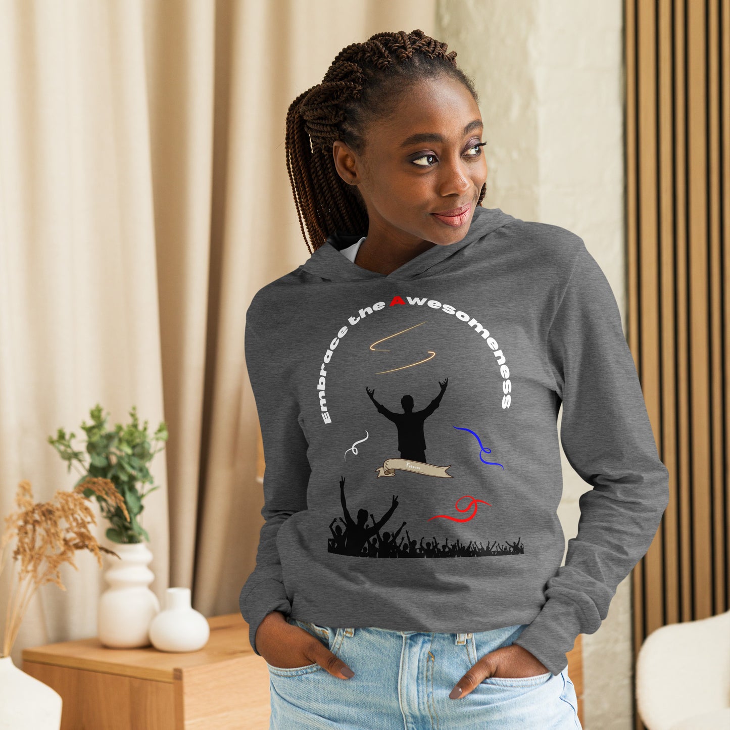 woman in long sleeve grey hoodie with words embrace the awesomeness inscribed in a half circle around a man with arms raised up you see whate blue and red colors featured and a crowd of people cheering in the background from the bottom