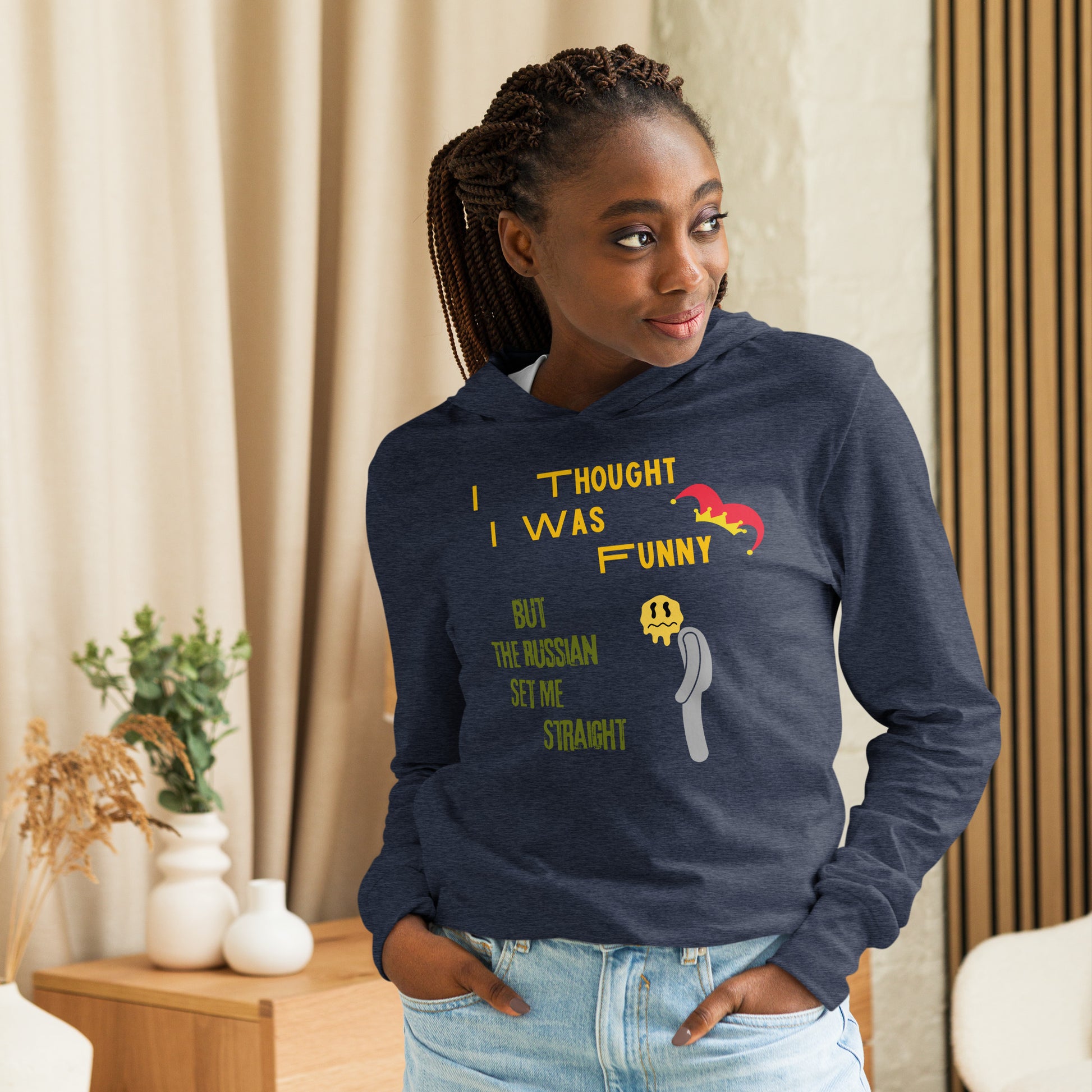 woman in heather navy blue unisex hoodie with i thought i was funny written in yellow and but the russian set me straight written in green a jasper hat is on funny and a sad man is next to green text