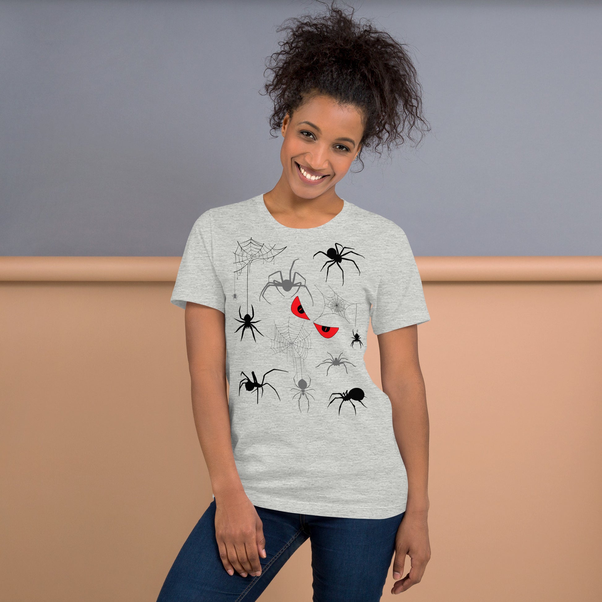 Woman in an athletic heather grey unisex t-shirt with creepy spiders, spider webs and malicious red eyes. 