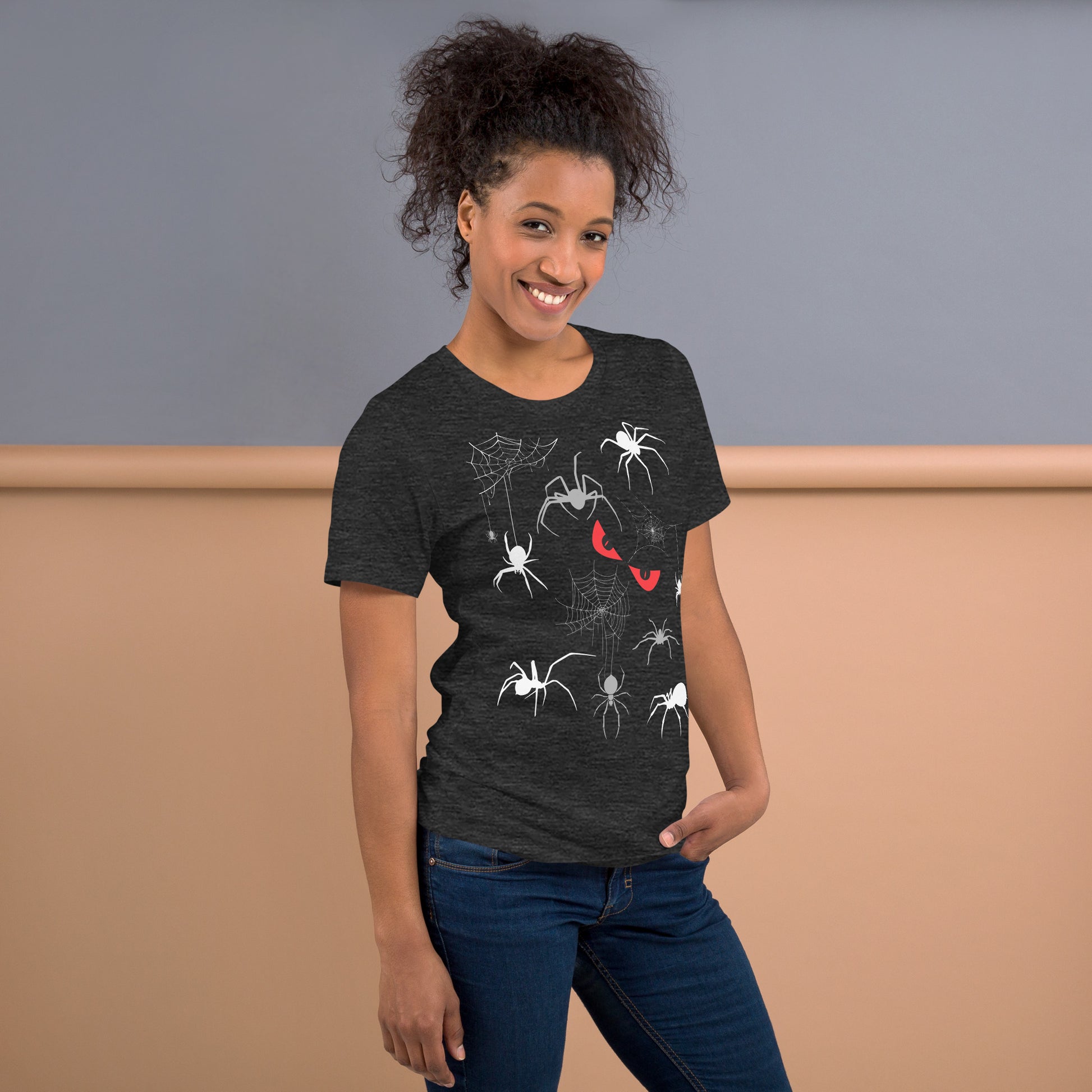 Woman in a unisex dark grey heather t-shirt with creepy spiders, spider webs and malicious red eyes. 