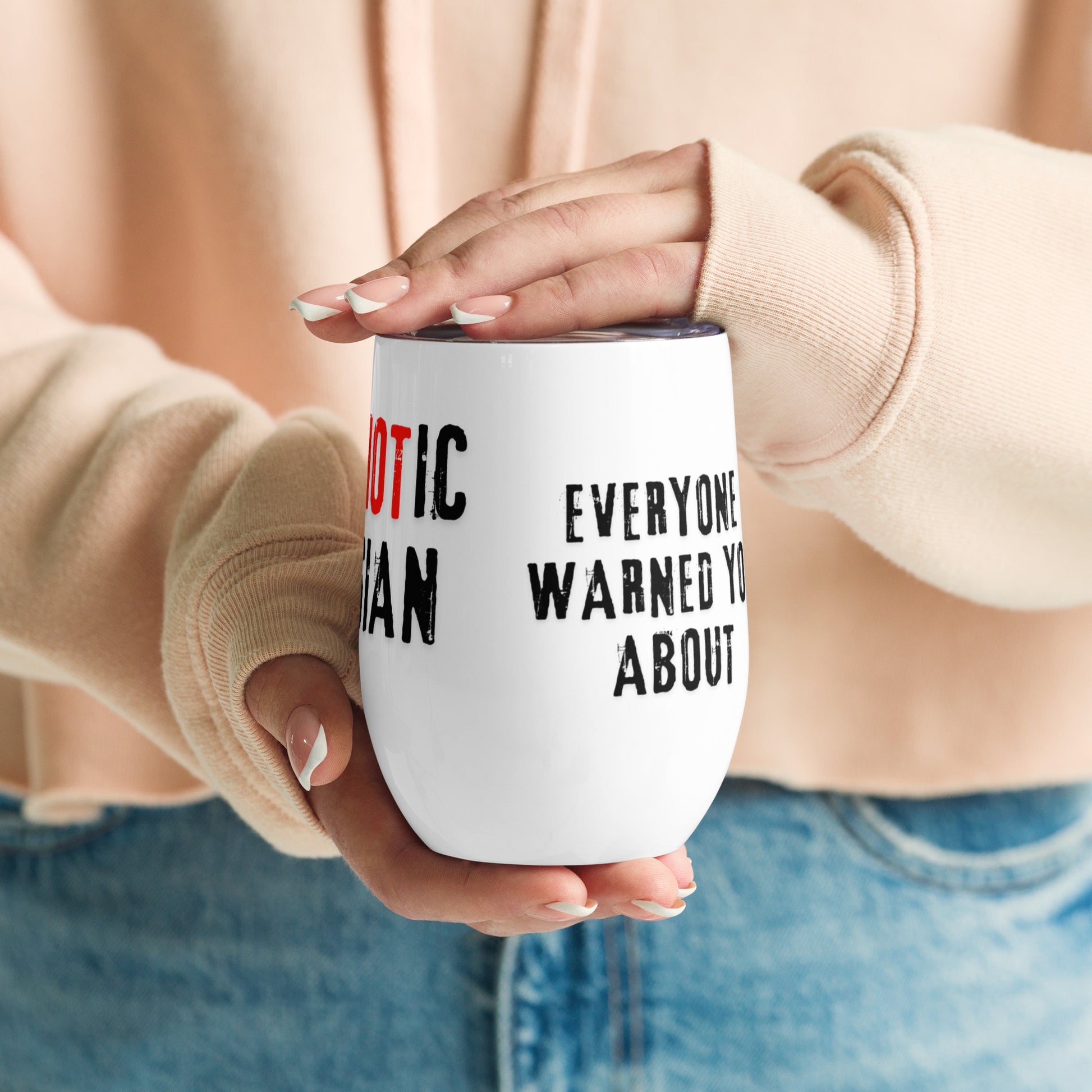 Woman holding a 12oz stainless steel wine tumbler with "I am the PsycHOTic Russian Everyone Warned You About". Double-wall insulated for hot or cold drinks.