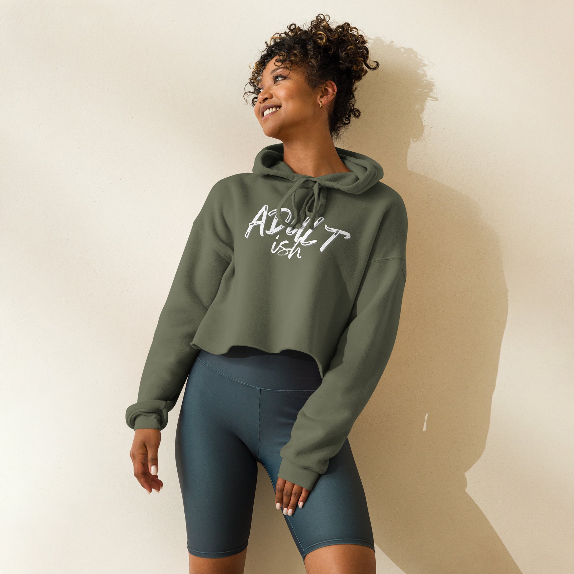 Woman in a green crop hoodie with "Adult-ish" caption.